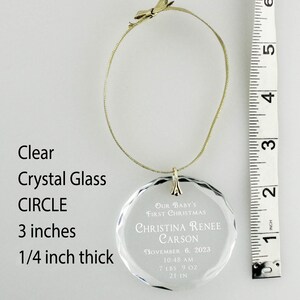 May include: Clear crystal glass circle ornament with the text "Our Baby's First Christmas Christina Renee Carson November 6, 2023 10:48 AM 7 LBS 9 OZ 21 IN". The ornament is 3 inches in diameter and 1/4 inch thick.