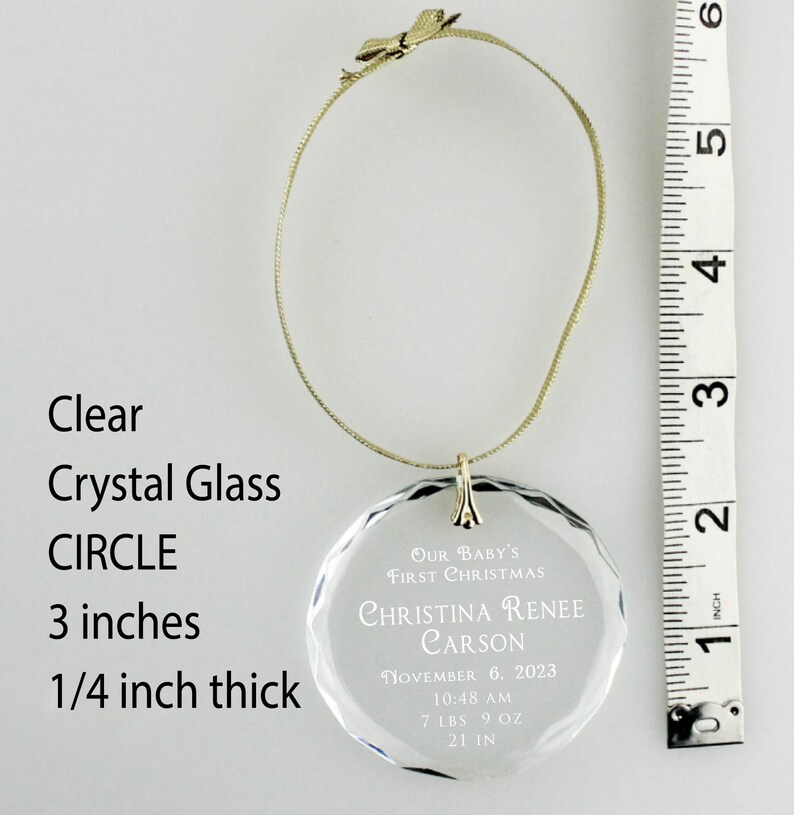 May include: Clear crystal glass circle ornament with the text "Our Baby's First Christmas Christina Renee Carson November 6, 2023 10:48 AM 7 LBS 9 OZ 21 IN". The ornament is 3 inches in diameter and 1/4 inch thick.