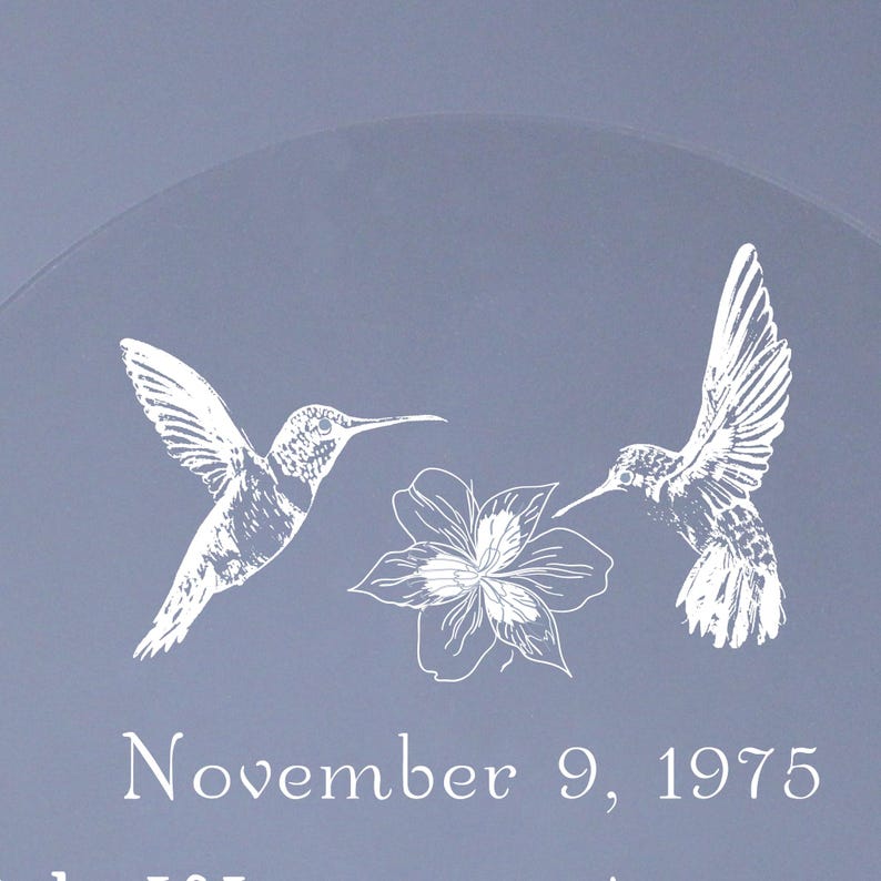 May include: A light blue decorative item with white hummingbird and flower illustrations. The text "November 9, 1975" is also visible. The design features two hummingbirds and a flower.