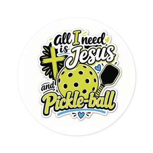 May include: A circular sticker featuring a yellow pickleball, a black paddle, and a yellow cross. The text reads "all I need is Jesus and Pickle-ball" in black and yellow lettering, accented with small blue hearts on a white background.