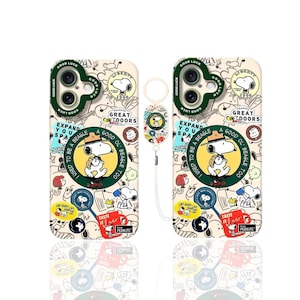 Puede incluir: Dos fundas de teléfono beige con diseños de Snoopy y texto. Una funda incluye un charm de Snoopy a juego con un cordón. Las fundas tienen un borde de cámara verde y están decoradas con varios gráficos temáticos de Snoopy.
