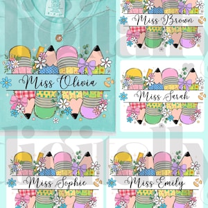 May include: A light blue Comfort Colors t-shirt with a pencil and floral design. The design includes pencils in yellow, green, pink, and purple, with the name "Miss Olivia" in a banner. The image also shows four name tags with different names.