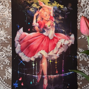 Może przedstawiać: Grafika przedstawiająca baletnicę w czerwono-białej sukience z falbaniastą spódnicą i różowymi baletkami. Ilustracja ma ciemne tło z kolorowymi iskierkami i podpisem w lewym dolnym rogu.