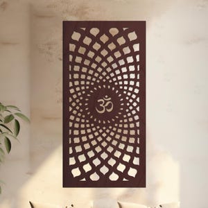 May include: A dark brown wooden wall art panel featuring a geometric pattern and the Om symbol. The rectangular panel hangs above a wooden bench with cream cushions. The design is a series of concentric circles, creating a focal point.