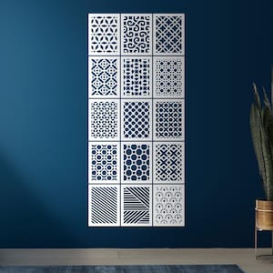 Peut inclure: Douze panneaux décoratifs blancs avec divers motifs géométriques découpés, montés sur un mur bleu foncé. Les panneaux présentent des motifs floraux, circulaires et linéaires, créant un contraste saisissant. Décoration murale.