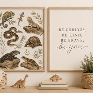 Puede incluir: Dos láminas de arte mural con marcos de madera clara. La lámina izquierda muestra ilustraciones de un camaleón, serpiente, tortuga y lagartos en tonos tierra. La lámina derecha muestra el texto: BE CURIOUS, BE KIND, BE BRAVE, be you.