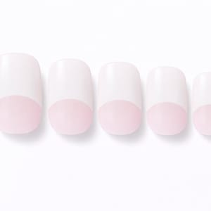 May include: Five white press-on nails with a rounded, pale pink tip. The nails are arranged in a row against a white background, showcasing a classic French manicure style. The nails are of varying sizes.