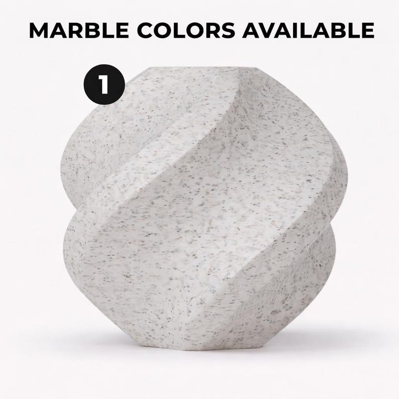 May include: A white marble sculpture with a unique, twisted design. The sculpture has a speckled pattern and is labeled with the number 1. The text "MARBLE COLORS AVAILABLE" is at the top of the image.