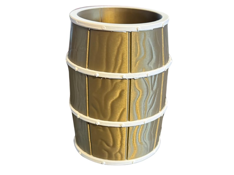 May include: A decorative barrel-shaped container with a gold finish and white trim. The container has a textured wood grain appearance and is banded with three white rings. The top and bottom edges are also trimmed in white.