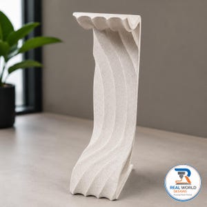 May include: A vertical, off-white, textured shelf bracket with a curved, wave-like profile and a flat top surface. The object features a speckled finish and a logo in the bottom right corner that reads REAL WORLD DESIGNS Practical Parts Printed.
