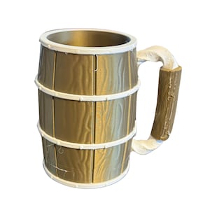 May include: A large, decorative mug with a barrel design. The mug is primarily gold with white accents around the top and the three bands. The handle is a light brown color. The mug is designed to look like a wooden barrel.