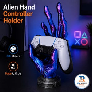 May include: An alien hand controller holder featuring a metallic blue and purple finish, designed to support a white and black gaming controller. The base is a dark grey circular stand. Text on the image reads Alien Hand Controller Holder.
