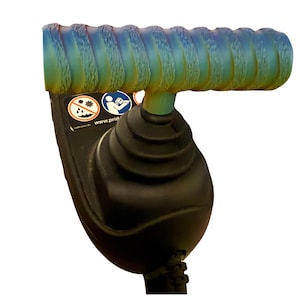 May include: A T-shaped joystick handle with a textured, iridescent blue and green finish attached to a black rubberized base. The base features a black accordion-style boot and two circular safety warning icons with the text www.pride.