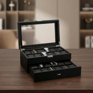 May include: A black watch box with a glass top and two drawers. The top drawer is open, revealing several watches and jewelry. The bottom drawer is partially open, also displaying watches and jewelry. The box is on a wooden surface.