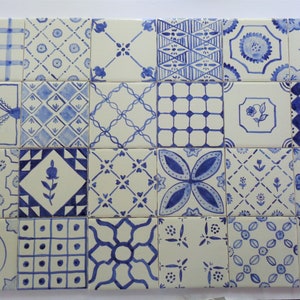 May include: A collection of 16 blue and white ceramic tiles with various geometric and floral patterns. The tiles are arranged in a grid pattern.
