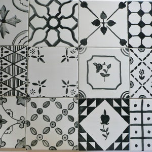 May include: A set of twelve black and white ceramic tiles with various geometric and floral patterns. The tiles are arranged in a grid pattern.