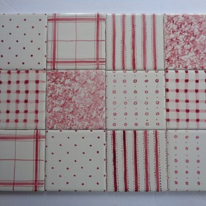 May include: A set of nine square ceramic tiles with various pink and white patterns. The patterns include polka dots, stripes, and plaid.