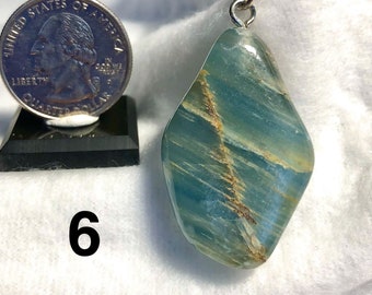 May include: A blue and gold agate pendant with a silver bail. The pendant is about the size of a quarter.