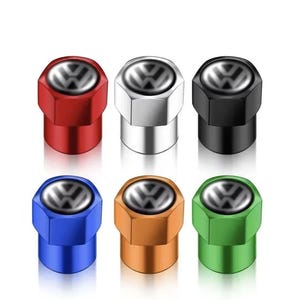 Puede incluir: Un juego de seis tapones hexagonales para válvulas de neumáticos en rojo, plata, negro, azul, naranja y verde. Cada tapón tiene una inserción circular negra en la parte superior con el logotipo de Volkswagen plateado en relieve.