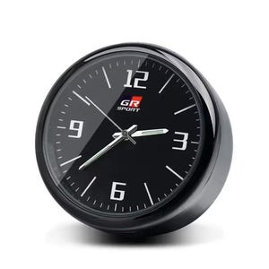 K&ouml;nnte beinhalten: Eine schwarze analoge Uhr mit wei&szlig;en Ziffern und Zeigern. Das Zifferblatt zeigt den Text "GR SPORT" und die Zahlen 12, 3, 6 und 9. Die Uhr hat eine gl&auml;nzend schwarze L&uuml;nette und einen wei&szlig;en Hintergrund.