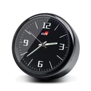K&ouml;nnte beinhalten: Eine schwarze analoge Uhr mit wei&szlig;en Ziffern bei 3, 6, 9 und 12. Das Zifferblatt hat die Buchstaben "GR" in Rot und Wei&szlig;. Die Uhr hat eine schwarze L&uuml;nette und eine transparente Glasabdeckung.