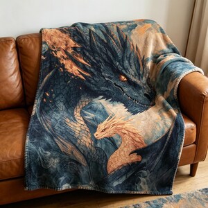 May include: A white ceramic mug with a black handle and the text "But First, Coffee" in a bold, black font. The mug is filled with a dark liquid, likely coffee, and rests on a light-coloured surface.