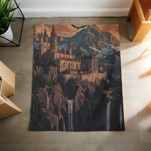 May include: A rectangular rug with a detailed illustration of a castle on a cliff, with waterfalls. The artwork includes a mountain range, a flying dragon, and a sunset sky. The colour palette includes shades of brown, beige, and blue.