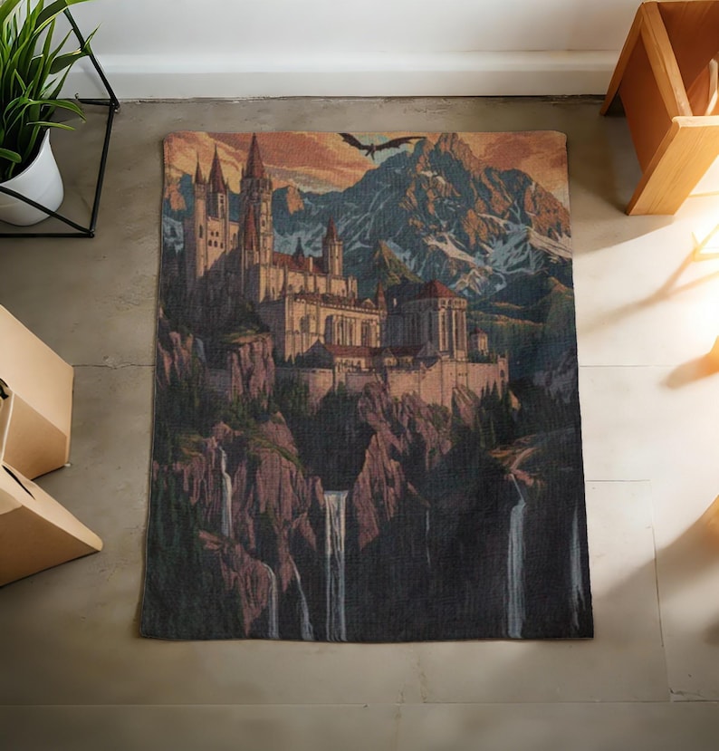 May include: A rectangular rug with a detailed illustration of a castle on a cliff, with waterfalls. The artwork includes a mountain range, a flying dragon, and a sunset sky. The colour palette includes shades of brown, beige, and blue.