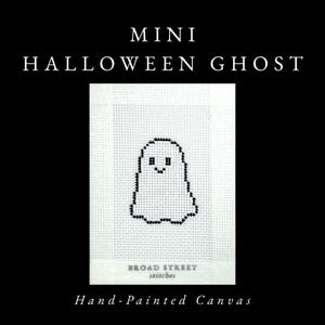 May include: A white needlepoint canvas featuring a black cross-stitched ghost design. The text MINI HALLOWEEN GHOST appears at the top, while BROAD STREET stitches and Hand-Painted Canvas are printed at the bottom of the white fabric square.