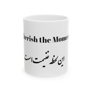 May include: White ceramic mug with the text "cherish the Moment" in black, along with text in a different language. The mug is cylindrical and has a simple, clean design, suitable for hot beverages.