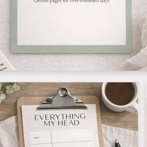 May include: A white notepad with the text "BURNT-OUT MUM RESET KIT" and "Gentle pages for overwhelmed days" is displayed. Below, a clipboard with the text "EVERYTHING MY HEAD" and categories like "KIDS" and "MONEY" is shown. A pen and a cup of coffee are also visible.