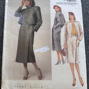 May include: A Vogue Patterns American Designer sewing pattern envelope by Perry Ellis, number 1354. The front displays illustrations of a two-piece outfit featuring a cropped jacket and a wrap skirt, shown in both dark grey and light beige colorways.