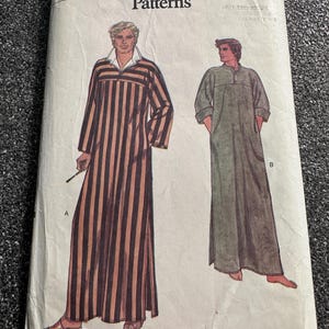 May include: Vintage Vogue Patterns sewing pattern. The pattern features illustrations of two long robes. One robe is striped in brown and tan, and the other is solid green. The pattern size is X-Large.
