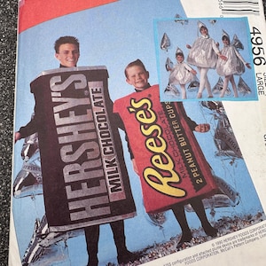 Pode incluir: Padrão de costura McCall's com designs de fantasias. Uma fantasia é uma barra de chocolate Hershey's Milk Chocolate, e a outra é uma barra de chocolate Reese's Peanut Butter Cups. Uma imagem menor mostra crianças em fantasias prateadas com chapéus cônicos.