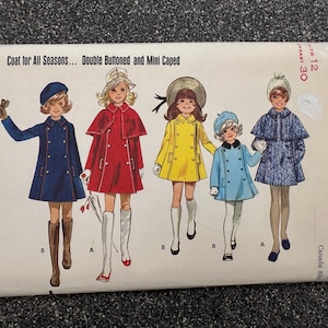 May include: A Butterick 5443 sewing pattern envelope for a coat with double buttons and a mini cape. The illustration shows five variations of coats in blue, red, yellow, light blue, and a blue patterned fabric, each paired with hats and boots.
