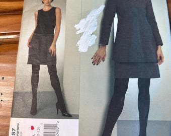 May include: A DKNY Vogue American Designer sewing pattern envelope V1057, size AA (6-8-10-12). The front displays two garment variations: a sleeveless top with a skirt and a long-sleeved jacket with a skirt, both in dark gray fabric.