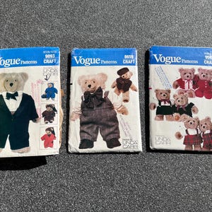 May include: Three vintage Vogue Patterns for teddy bear clothing. The patterns feature illustrations of teddy bears in various outfits, including a tuxedo, overalls, and other attire. The patterns are labeled with the Vogue Patterns and Linda Carr branding.