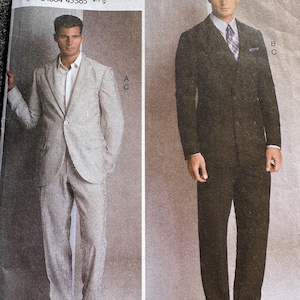 May include: Vogue Patterns sewing pattern featuring two men's suit designs. One suit is a light gray and white striped design, and the other is a solid black suit. The pattern includes sizes 34-40.