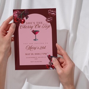 Pu&ograve; includere: Un biglietto d'invito bordeaux e rosa con il testo "She's the Cherry On Top" e "Mary's 21st". Il biglietto presenta un'illustrazione di cocktail e dettagli di ciliegie. Sono inclusi anche data e ora.