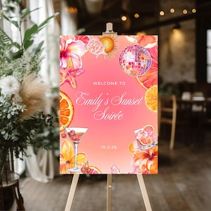 Op de afbeelding: Een roze welkomstbord op een ezel met de tekst "Welcome to Emily's Sunset Soirée" en de datum 10.2.26. Het bord bevat aquarel illustraties van een discobal, cocktails en tropische bloemen.