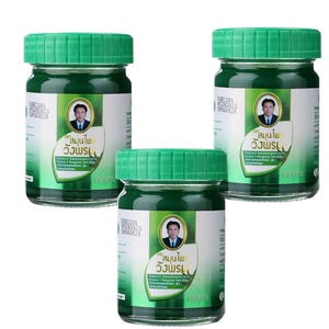 Pode incluir: Três frascos de vidro com tampas verdes. Cada frasco tem um rótulo branco com texto e um retrato de um homem. Os frascos são preenchidos com uma substância verde. Os rótulos têm texto em língua estrangeira.