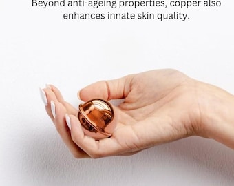 May include: A small, spherical, metallic copper-colored object with a smooth, reflective surface. The text above the object reads: Beyond anti-ageing properties, copper also enhances innate skin quality.
