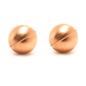 May include: A pair of spherical copper-toned stud earrings. Each earring features a smooth, polished surface with a distinct horizontal seam running across the center of the round shape, creating a simple and uniform metallic appearance.