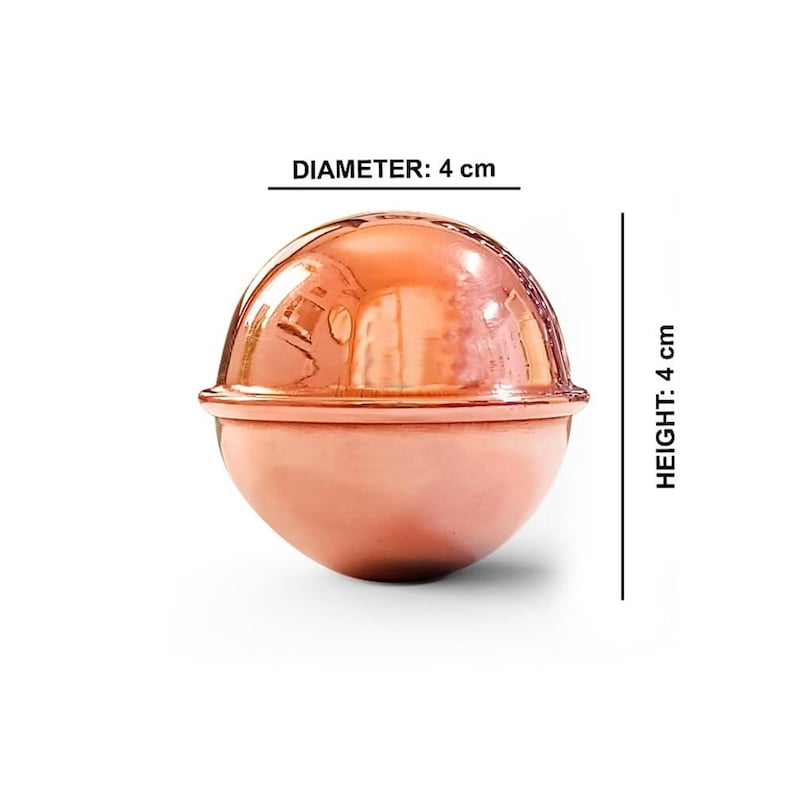 May include: A polished copper-colored spherical object with a horizontal seam around the center. The object features a reflective surface and is labeled with a diameter of 1.57 inches and a height of 1.57 inches, indicating its dimensions.
