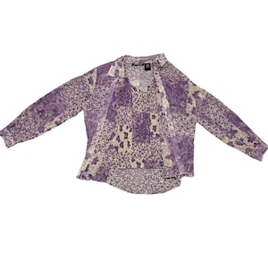 May include: A two-piece set featuring a long-sleeved button-down shirt and a tank top. The set is patterned with a mix of paisley and floral designs in shades of purple and cream.