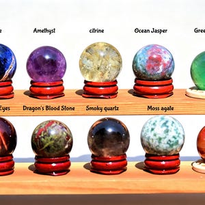 Può includere: Dieci sfere di pietre preziose levigate disposte su un espositore in legno a due livelli. Riga superiore: sodalite, ametista, citrino, diaspro oceanico, fluorite verde. Riga inferiore: occhio di tigre rosso, pietra del sangue, quarzo fumé, agata muschiata, agata rossa.