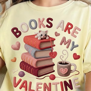 May include: Yellow t-shirt with the phrase "BOOKS ARE MY VALENTINE" in a 3D knitted style. The design includes a stack of books, a cat, hearts, and a coffee cup, all in a similar knitted style.