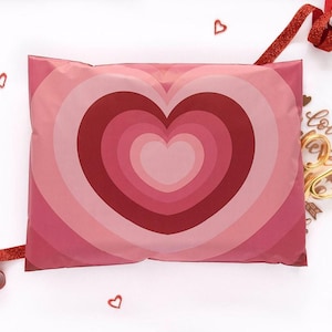 a pink pillow with a heart-shaped design, surrounded by red hearts and a red ribbon.