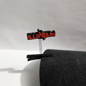 May include: A set of three ceramic mugs with a speckled, matte finish. The mugs are in shades of cream, light brown, and dark brown. Each mug has a simple, minimalist design and a rounded handle.