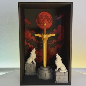 Könnte beinhalten: Ein gerahmtes Kunstwerk mit einem goldenen Schwert mit Wolfskopf-Knauf, vor einem Hintergrund aus rotem Mond und Wolken. Zwei weiße Wolfsfiguren sitzen auf grauen Steinsockeln. Das Kunstwerk ist in einem dunkelbraunen Rahmen eingefasst.